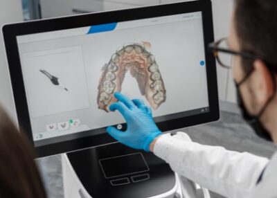 Denturist examing digital dentures on monitor